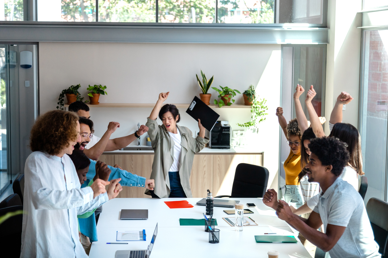 Multiracial coworkers and female hispanic boss dance in the office celebrating company results. Copy space. Business success concept.